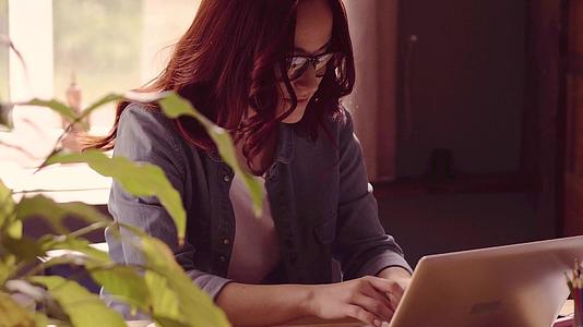 红发自由职业女性在笔记本电脑上工作视频的预览图