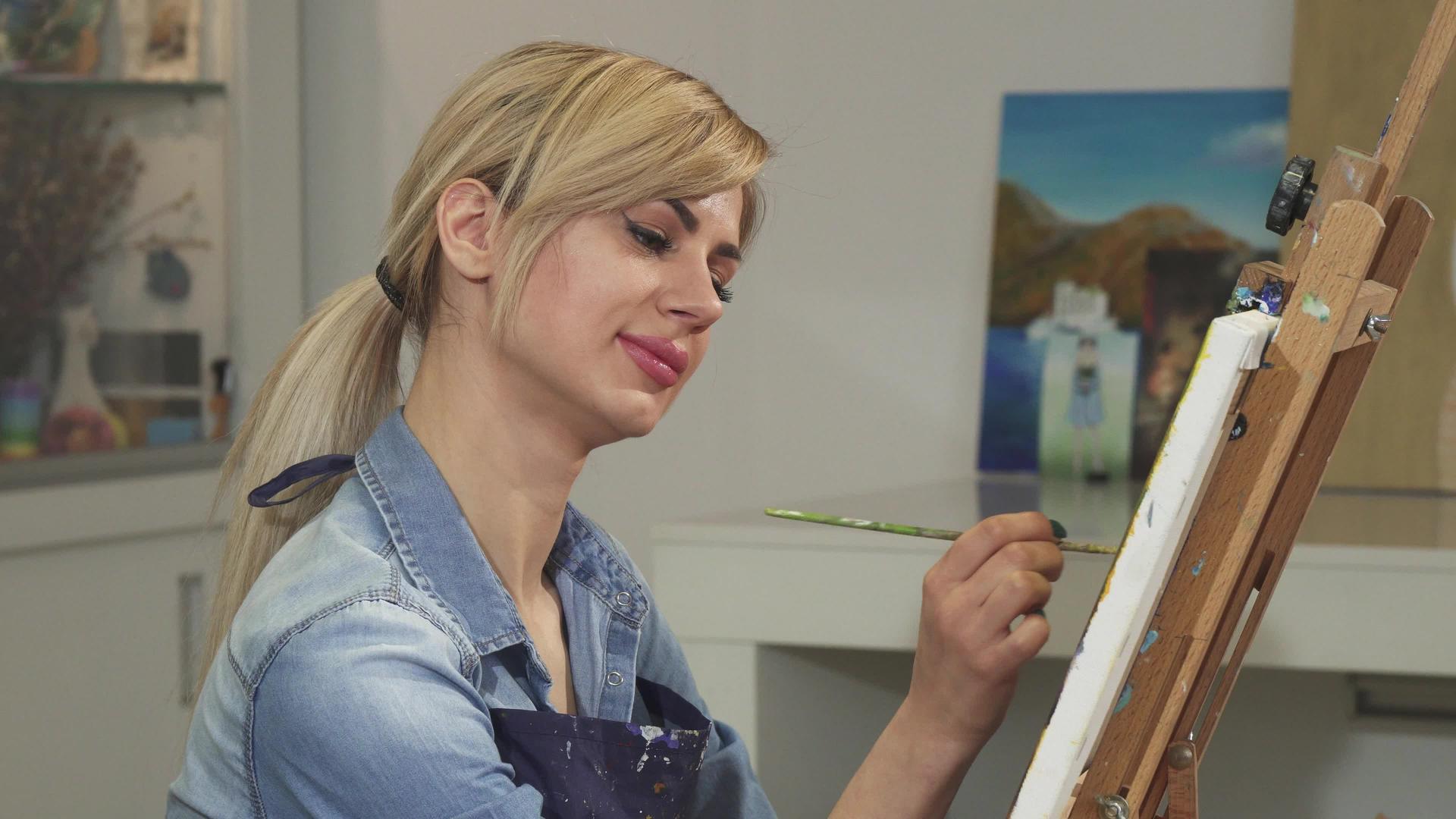 在她的工作室里一位美丽的女艺术家微笑着视频的预览图