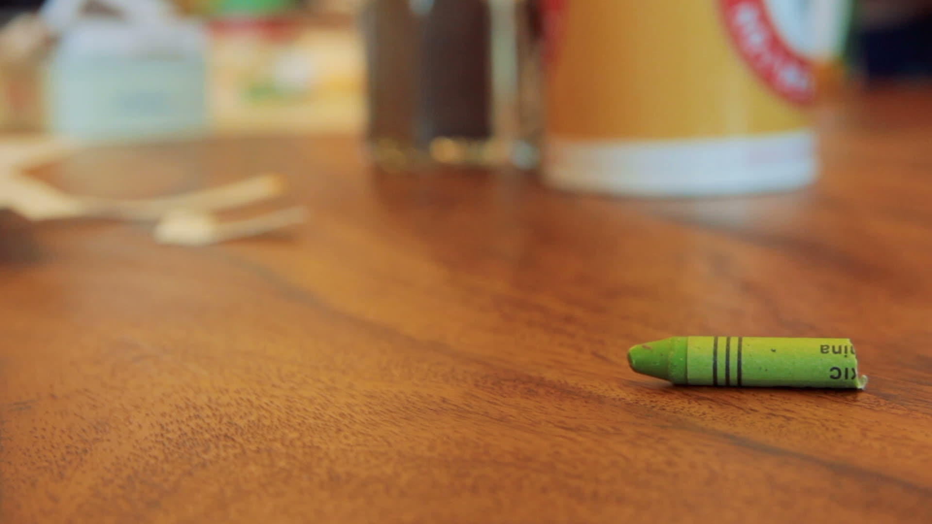 棕色木桌上的绿色纸蜡笔卷视频的预览图