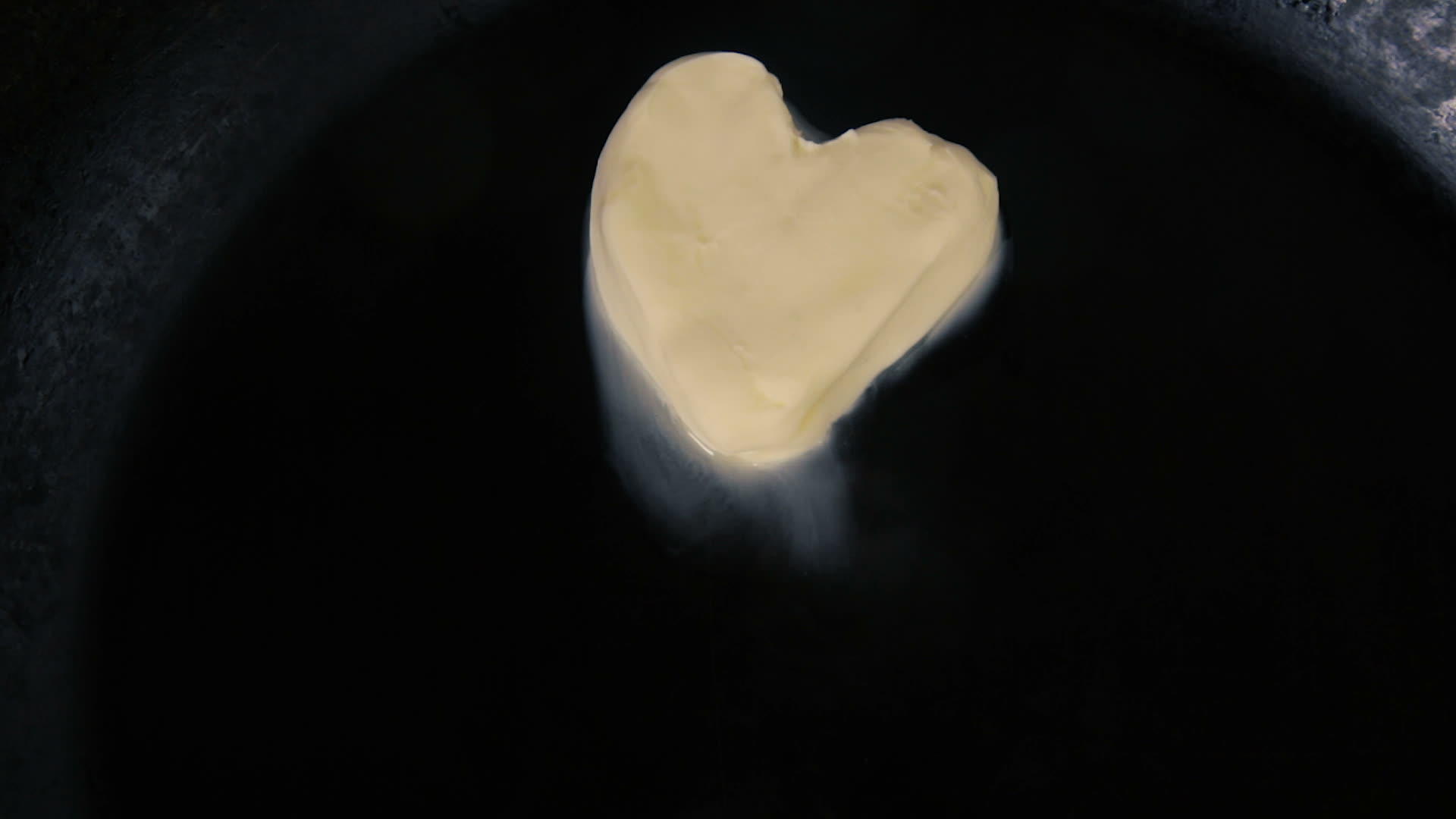 热锅上融化的心形黄油关闭顶部视图视频的预览图