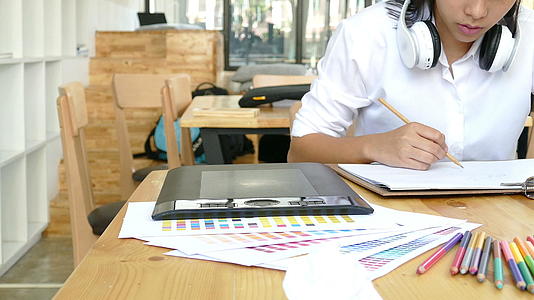 自由艺术家平面设计师在白纸上画画在木桌上用数字平板画画视频的预览图