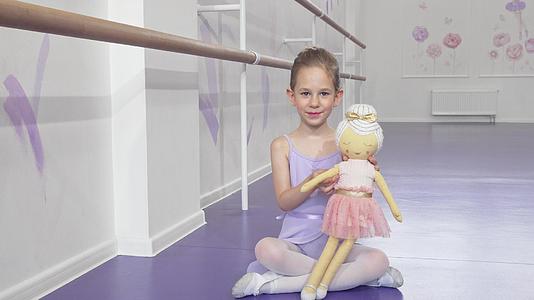 一个可爱的小芭蕾舞女在相机上挥舞着一个洋娃娃视频的预览图