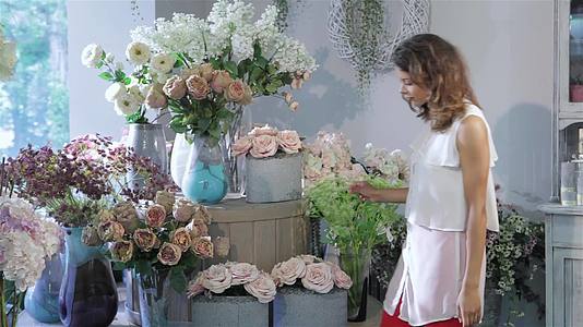 女性在花店的茶玫瑰和粉红玫瑰之间做出选择视频的预览图