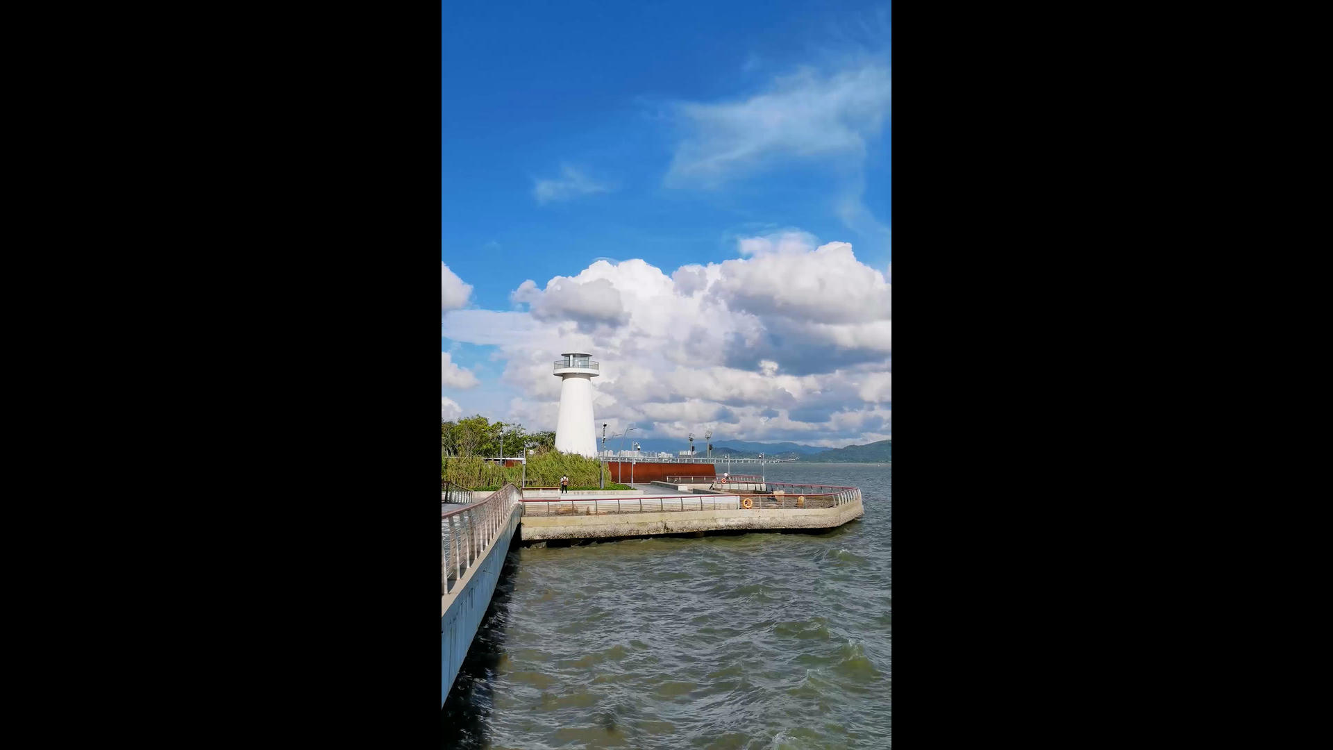 晴朗的天空下海岸边的灯塔竖屏视频的预览图