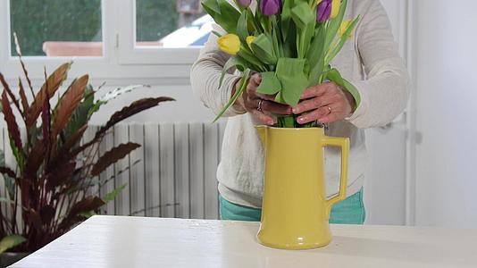 女人在花瓶里安排春暖花束视频的预览图