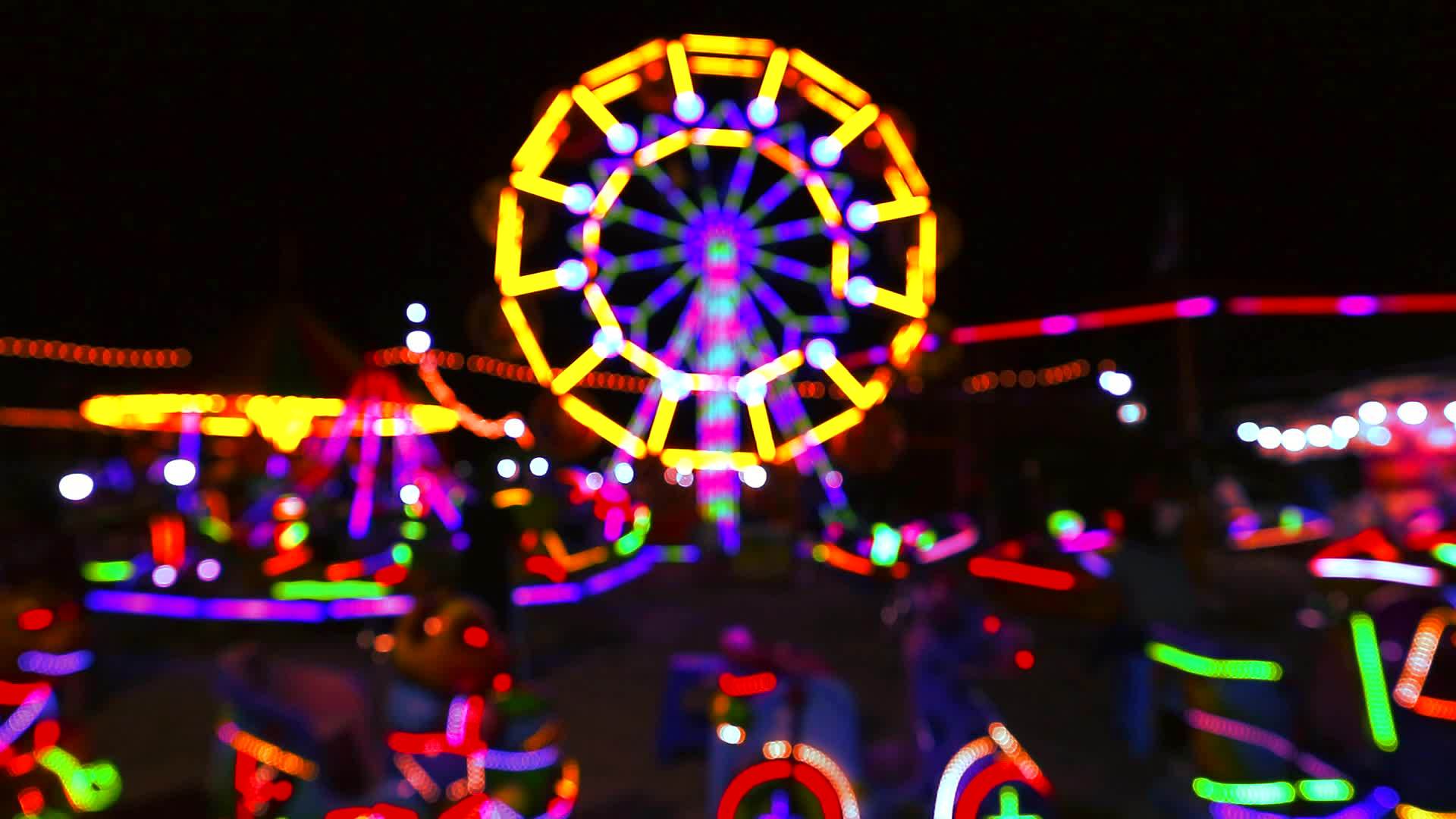 夜间市场主题公园的模糊发酵轮和滚动灯光视频的预览图