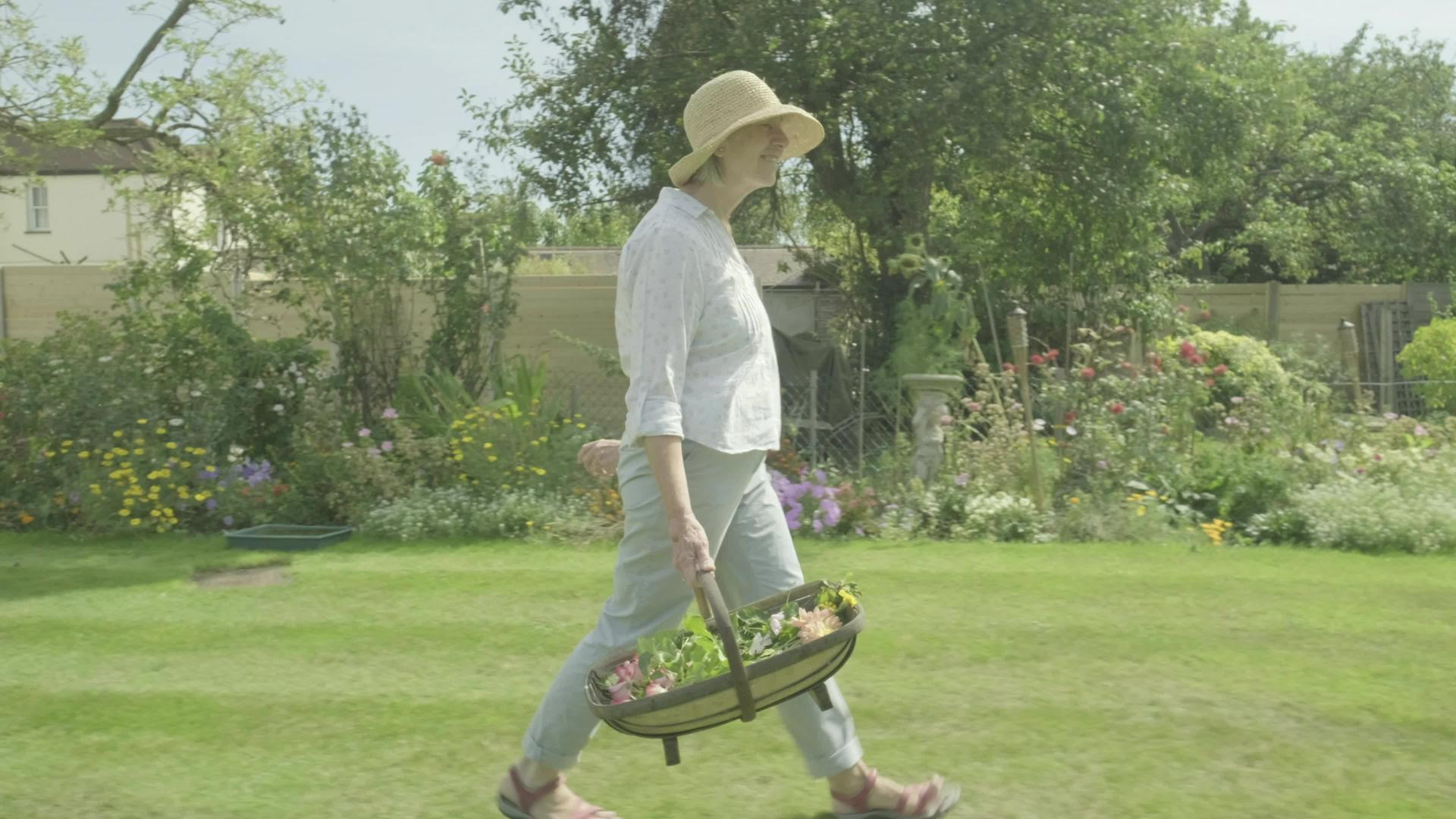 快乐的高加索老妇人在花园里旋转视频的预览图