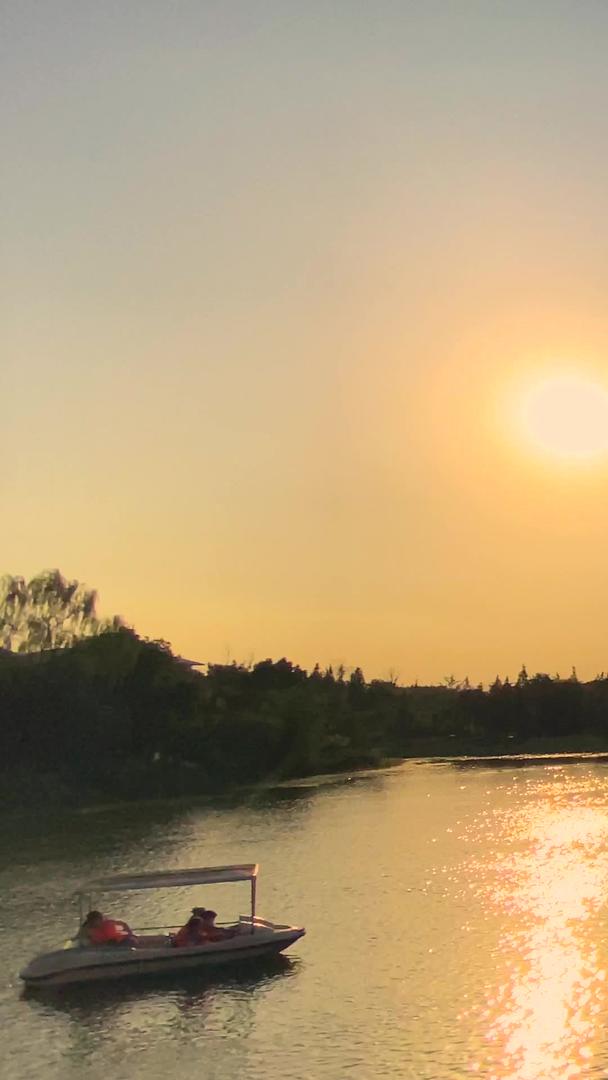 拍摄自然风景夕阳倒影湖中坐游船观光视频的预览图