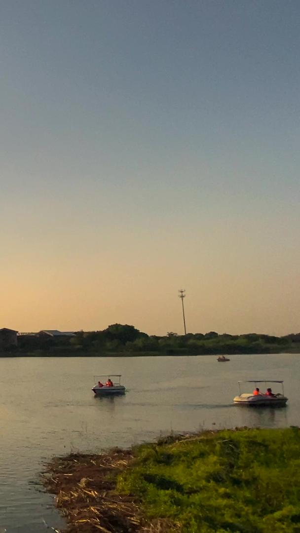 拍摄自然风景夕阳倒影湖中坐游船观光视频的预览图