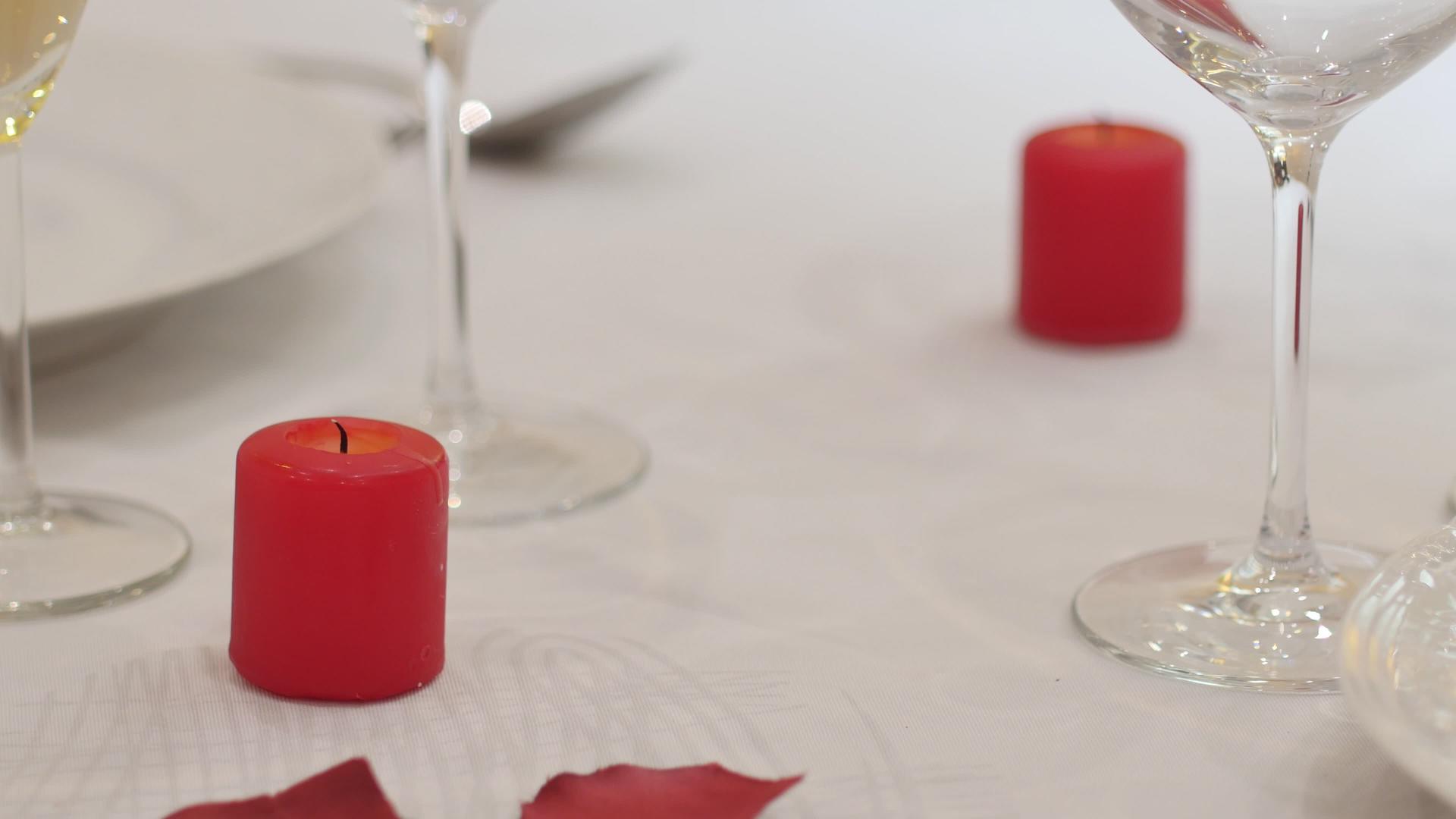 男服务员或情人把玫瑰花瓣放在桌子上准备情人节晚餐视频的预览图