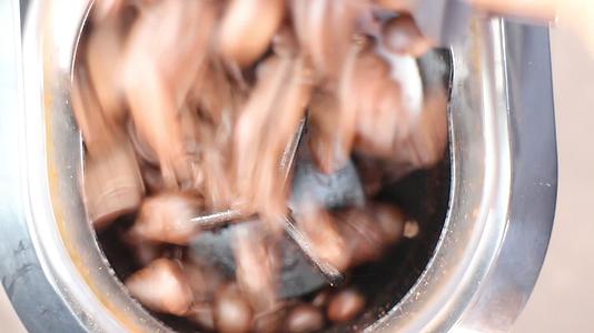 将烤好的咖啡豆倒入研磨机中视频的预览图