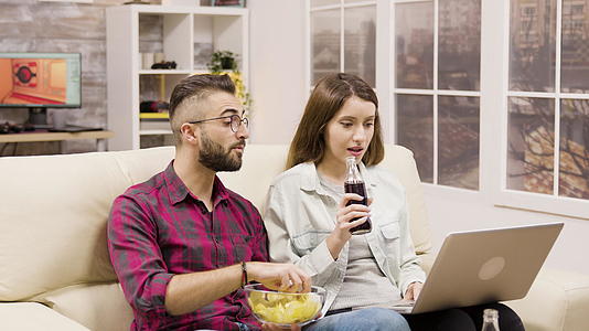 快乐的年轻夫妇在笔记本电脑上网上购物视频的预览图