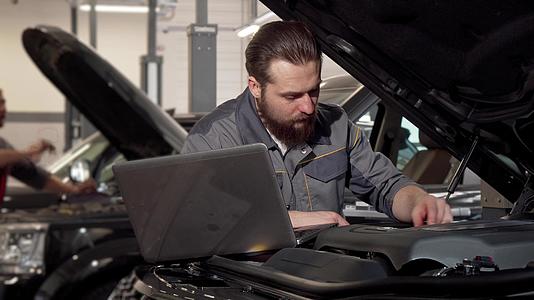 汽车服务工人使用膝盖电脑检查发动机视频的预览图