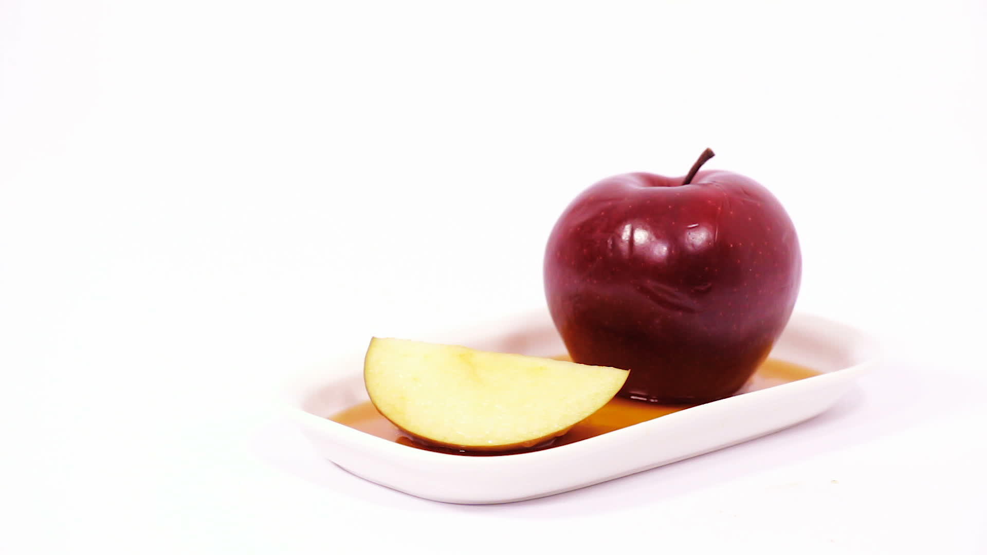 白色盘子上的红苹果和红苹果切片白底蜂蜜被孤立视频的预览图