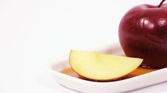 白色盘子上的红苹果和红苹果切片白底蜂蜜被孤立视频的预览图
