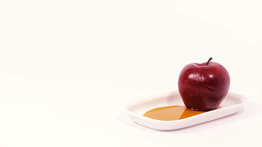 白色盘子上的红苹果和白底的蜂蜜被孤立了视频的预览图