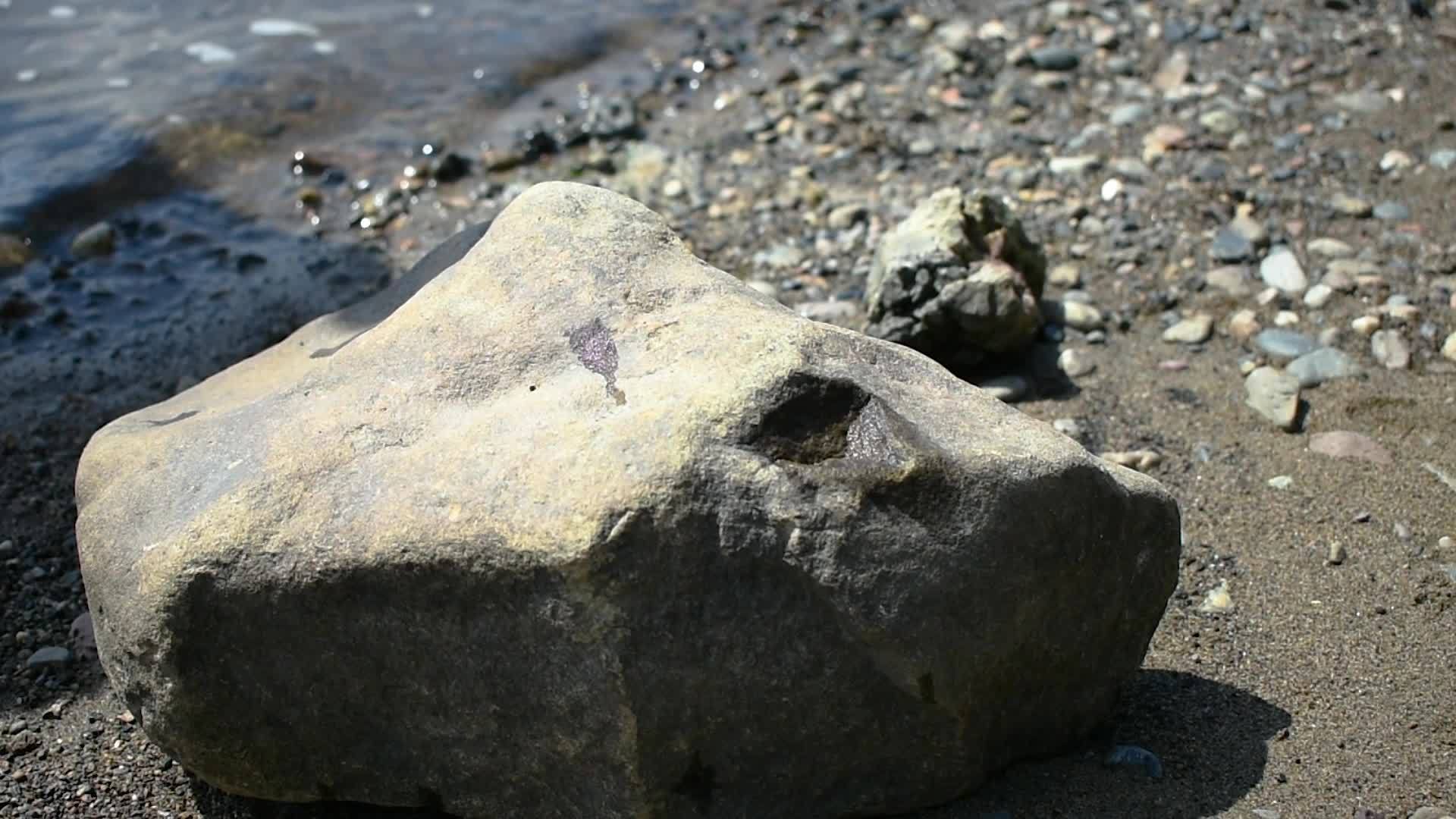 一个男人从水里出来象征性地把红苹果放在石头上视频的预览图