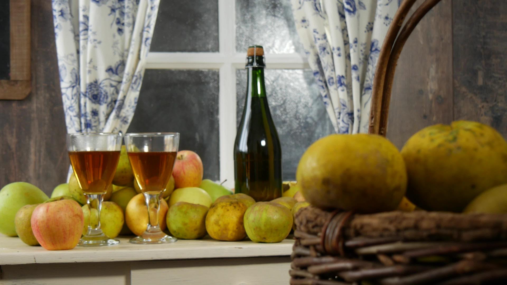 移动相机滑块显示瓶和苹果酒杯在简陋的房子里视频的预览图