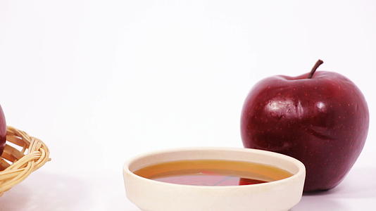 从一堆红苹果到红苹果和一碗蜂蜜滑雪片白色背景视频的预览图