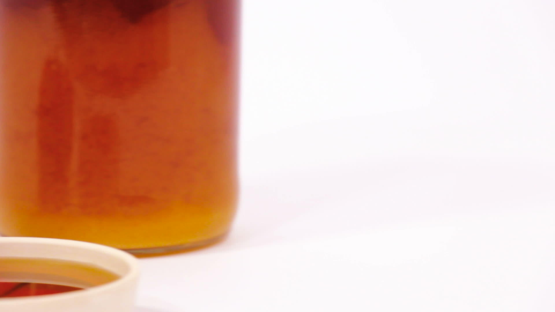 红苹果、一罐蜂蜜和一碗蜂蜜在白色背景下被孤立视频的预览图