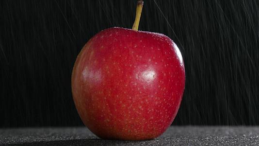 美丽的红苹果由细雨旋转视频的预览图