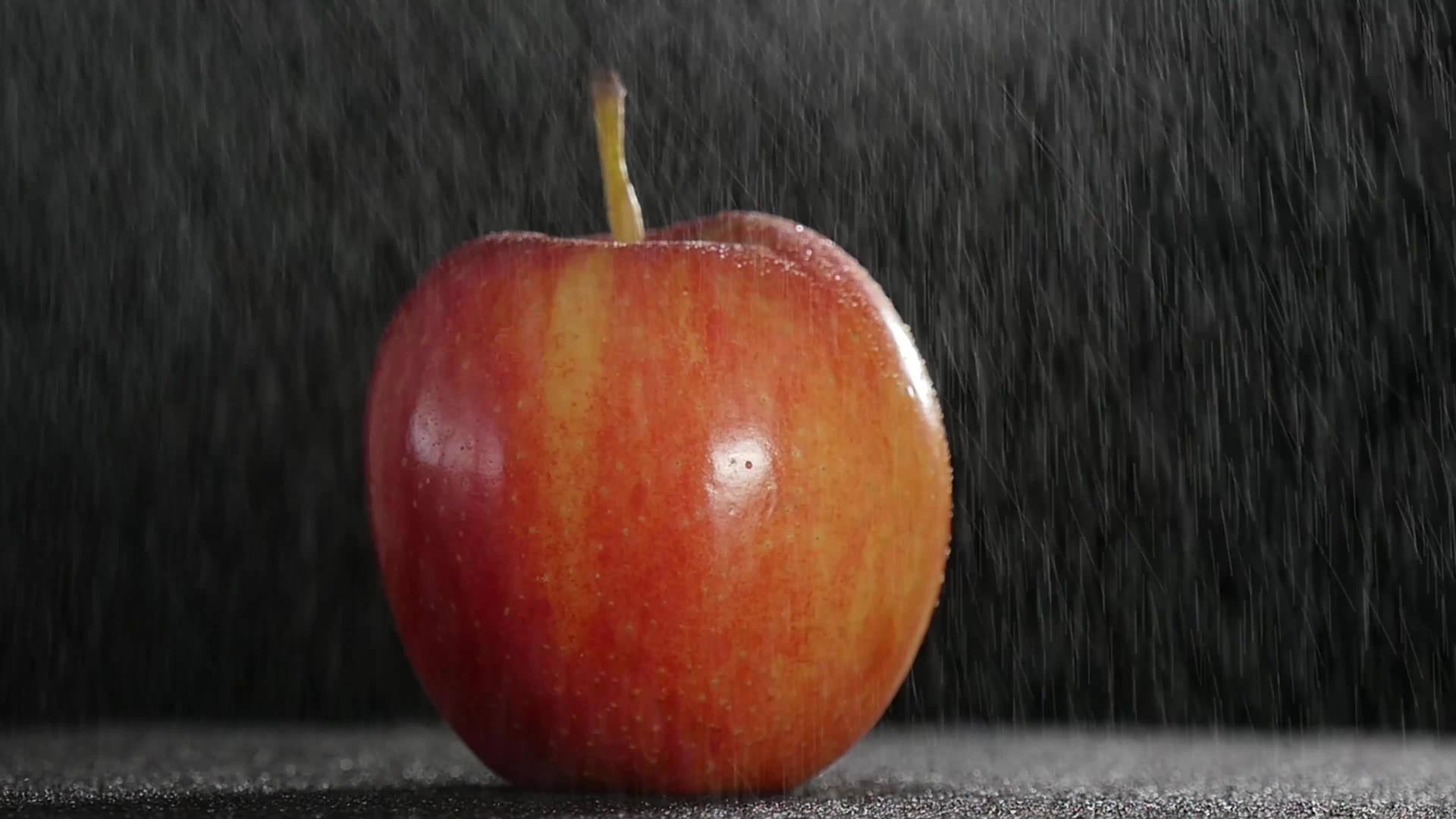 美丽的红苹果由细雨旋转视频的预览图