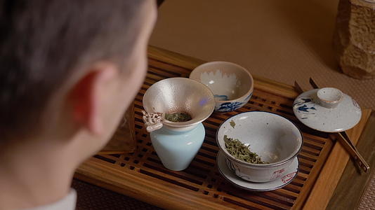 茶主会把热水从酒壶里倒到蒸汽绿茶里视频的预览图