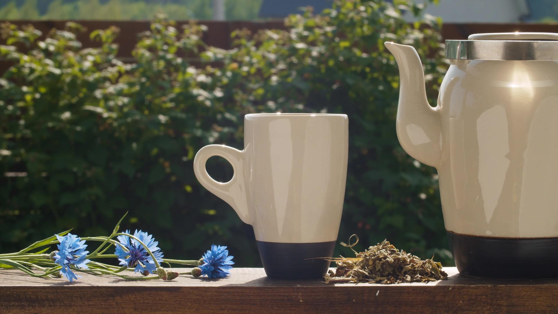 茶杯和茶壶放在花园的桌子上视频的预览图