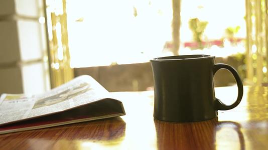 卡布奇诺咖啡香气杯咖啡早餐在木桌背景和报纸咖啡馆视频的预览图