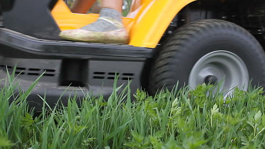 年轻女孩驾驶草坪搬运工割草视频的预览图