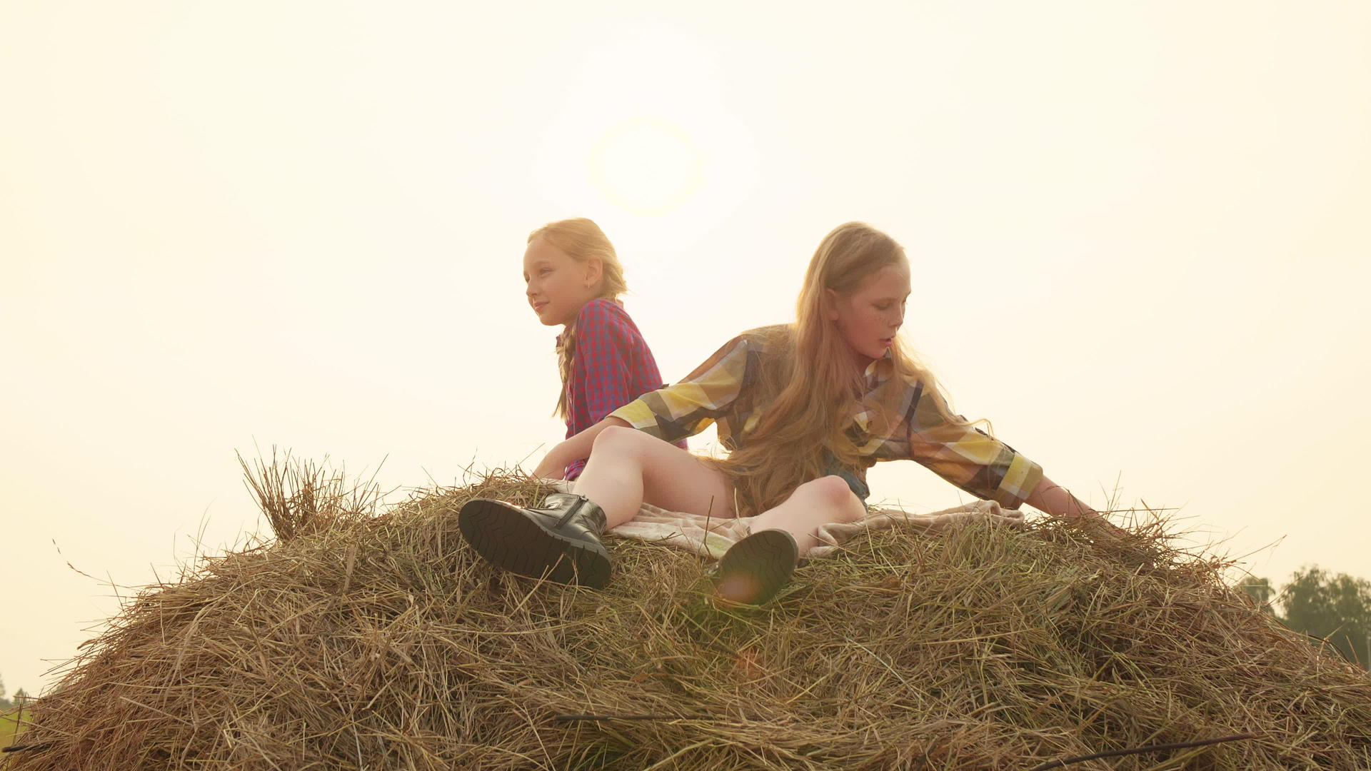 两个十几岁的女孩坐在干草堆上阳光明媚的一天视频的预览图