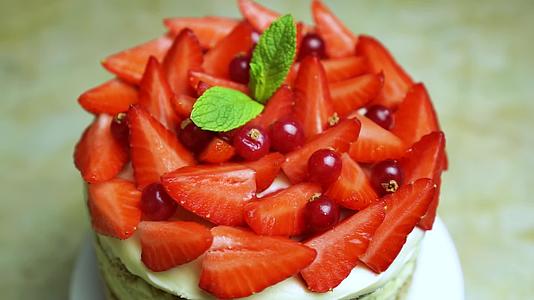 高速射击旋转草莓和薄荷用蔓越莓装饰美味蛋糕夏季美味佳肴视频的预览图
