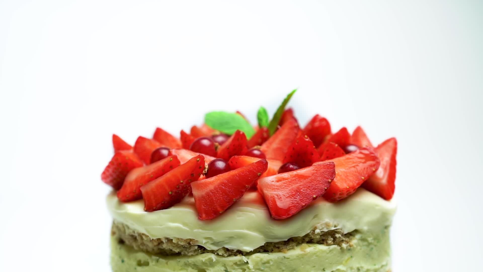 草莓和薄荷装饰的慢旋转美味蛋糕与白色背景隔绝视频的预览图
