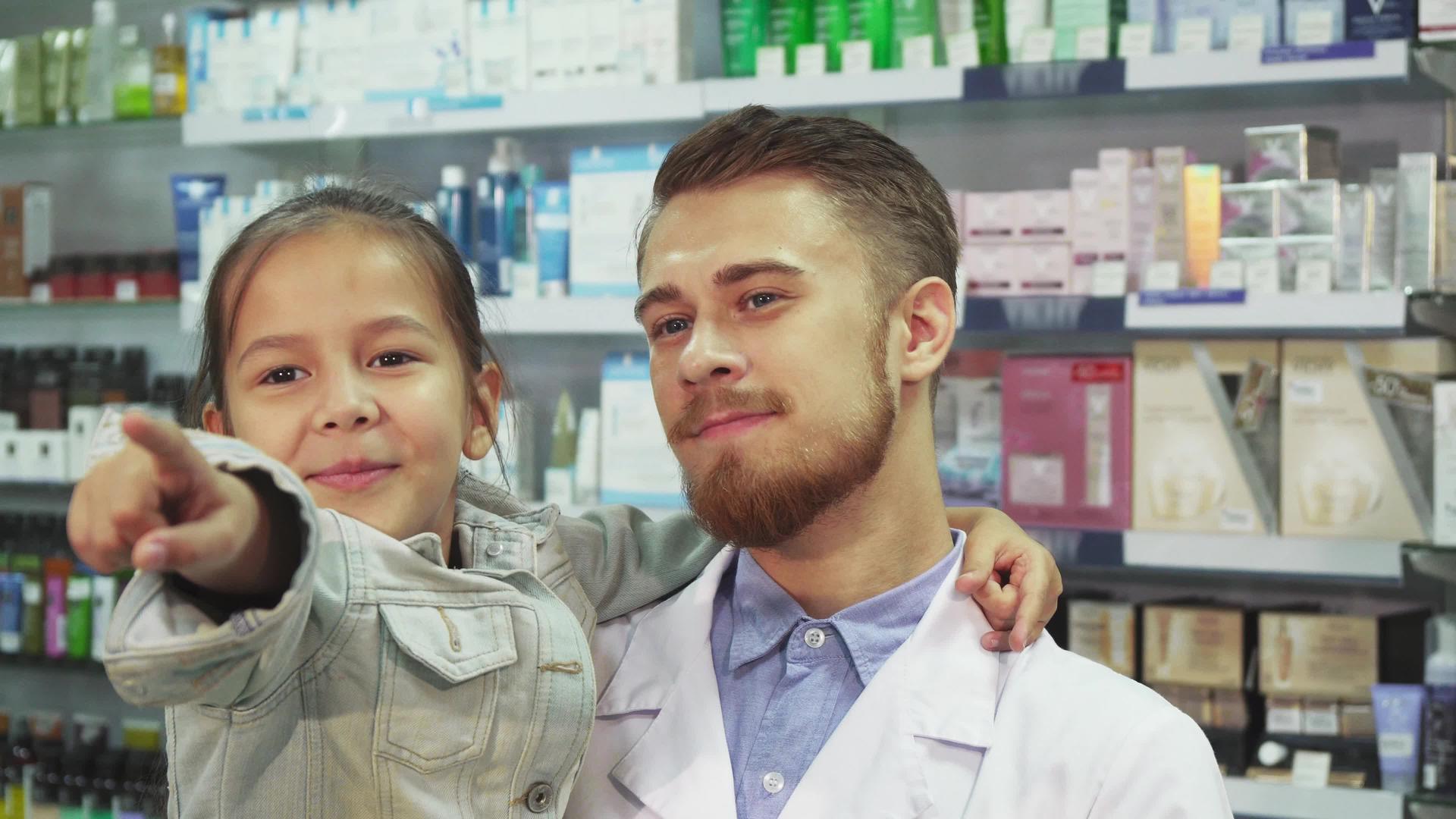 一位友好的药剂师把一个小女孩抱在怀里视频的预览图