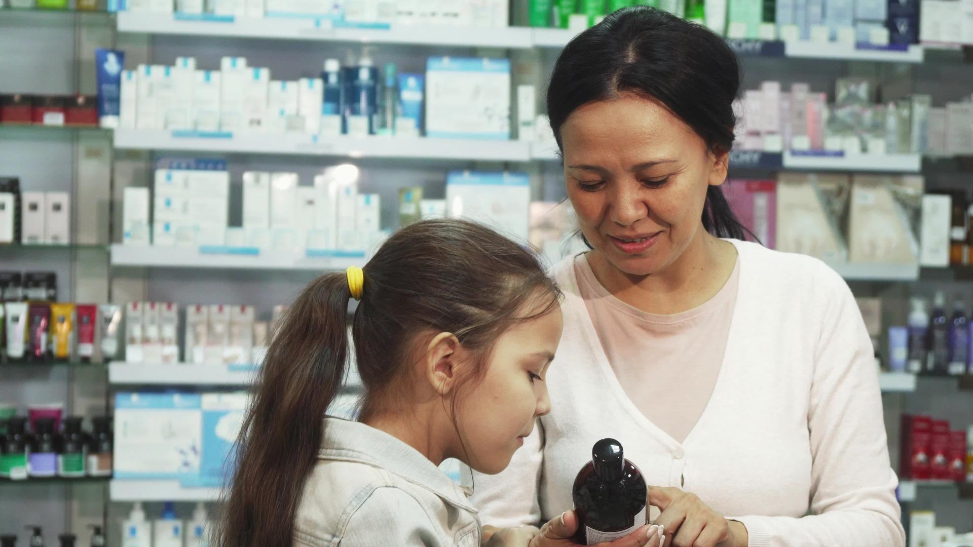 一个微笑的女人和她的女儿在药店里选择了一些东西视频的预览图