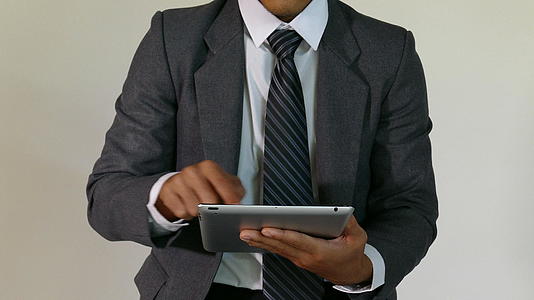 年轻的企业家和商人使用白色背景触摸屏数字平板电脑视频的预览图