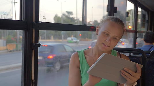 年轻女性乘坐公共汽车旅行时有触摸垫视频的预览图