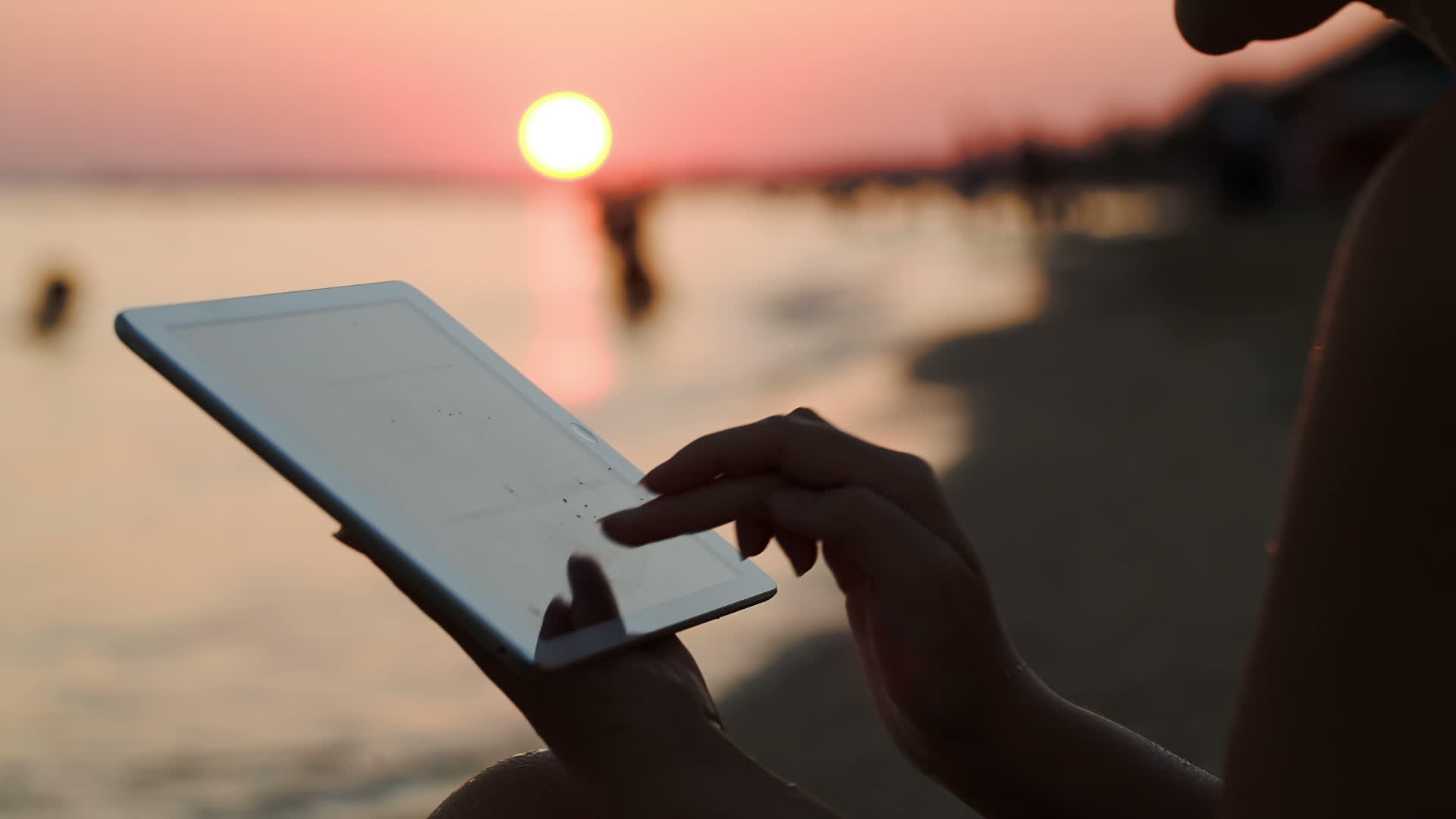日落时与平板电脑合作的女孩视频的预览图