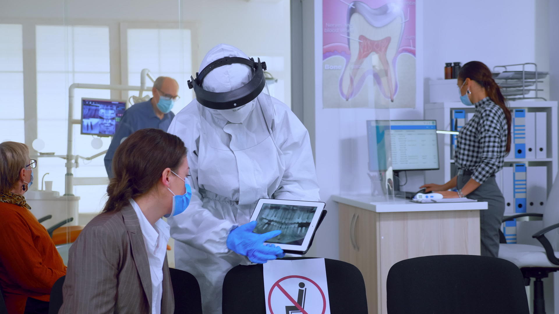 穿着防护服的口腔科学家指向数字射线视频的预览图