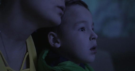 母亲和孩子在电影院看电影视频的预览图