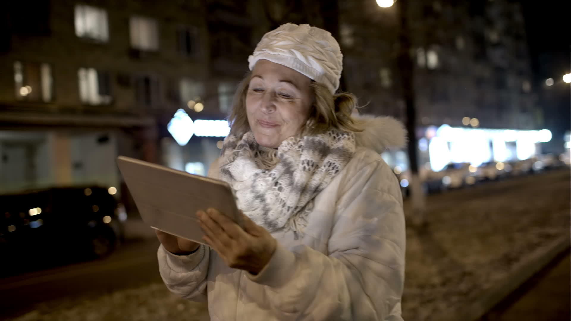 快乐的女人晚上散步时在床上看东西视频的预览图