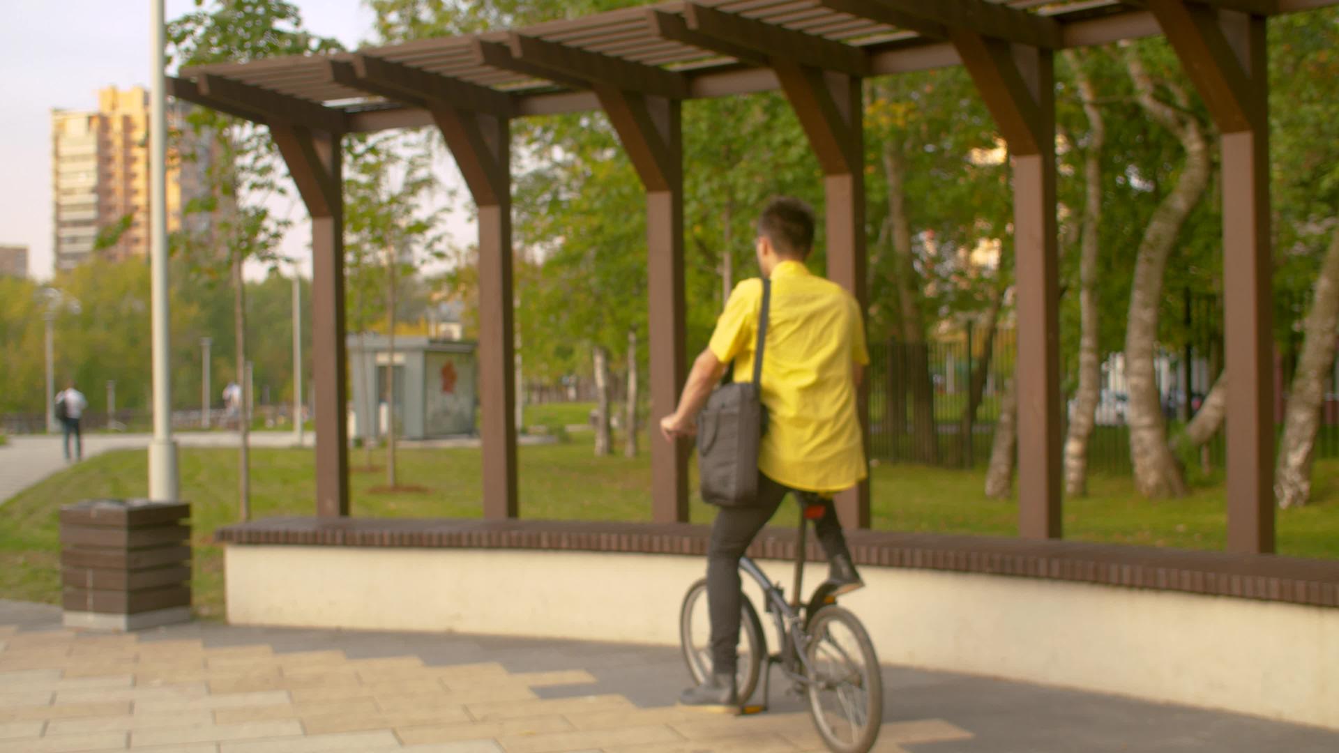一名身穿黄衬衣的男子在公园里工作视频的预览图