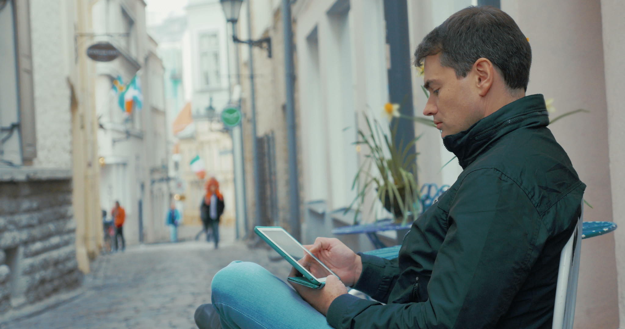 街上坐着平板电脑的成年男子视频的预览图