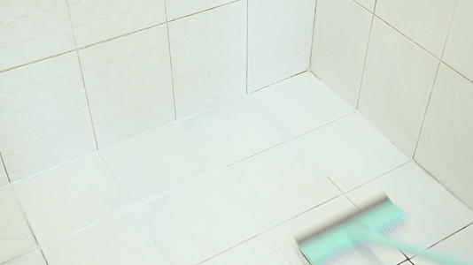 家庭主妇在度假时用刷子清洁浴室地板视频的预览图