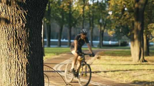 虚化拍摄夕阳下户外公园自行车骑行视频的预览图