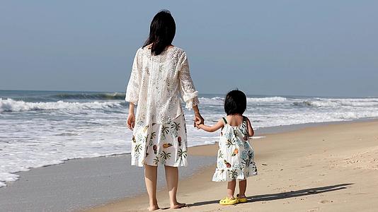 夏季母女海边海浪温馨散步母亲玩耍视频的预览图