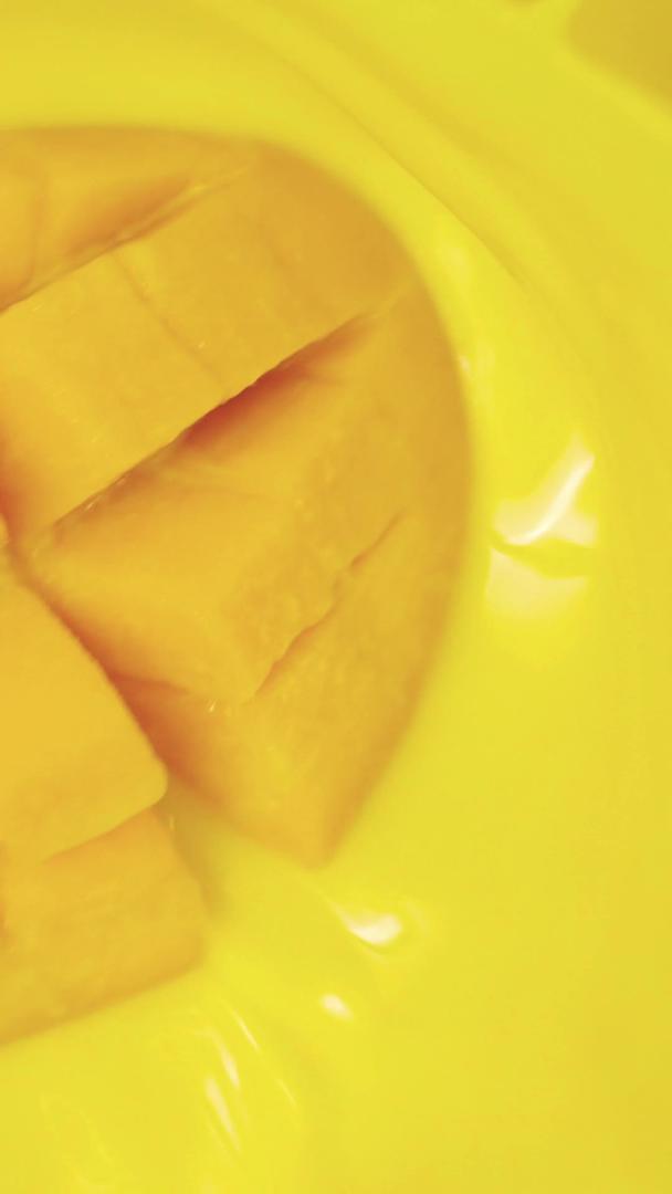 金黄色芒果落入果汁水中视频的预览图