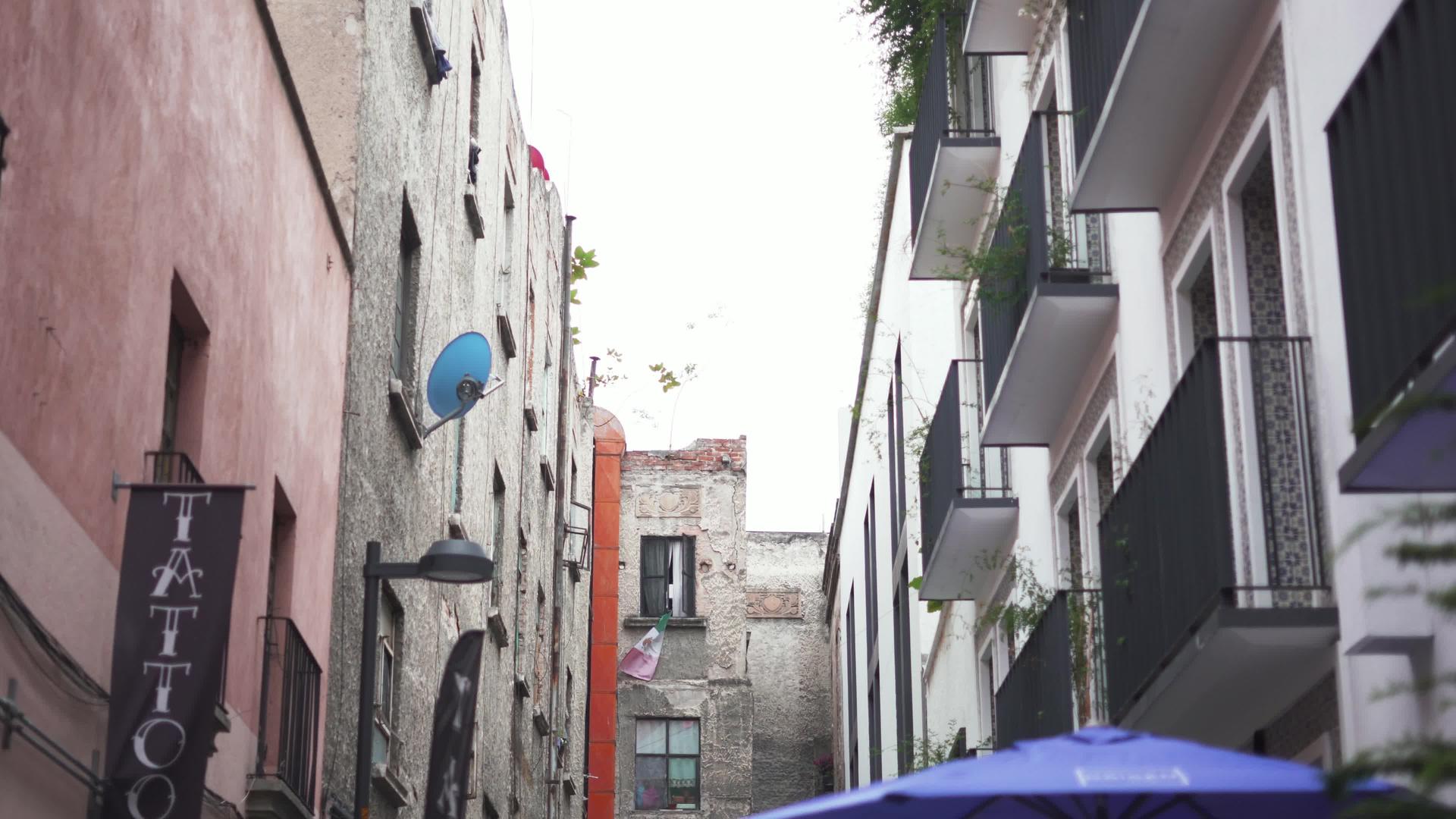 蓝色雨伞和纹身工作室的小巷向后移动视频的预览图