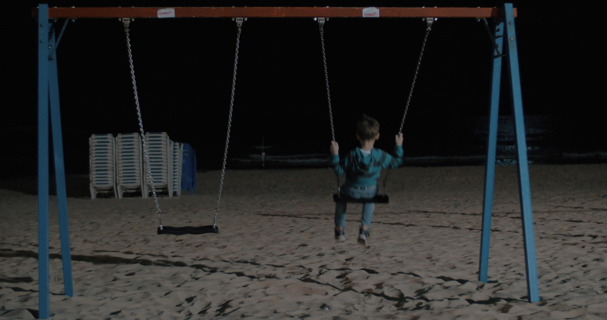 孤独的孩子晚上在海滩上摇摆视频的预览图
