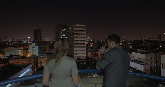 晚上男人和女人从酒店屋顶看风景视频的预览图